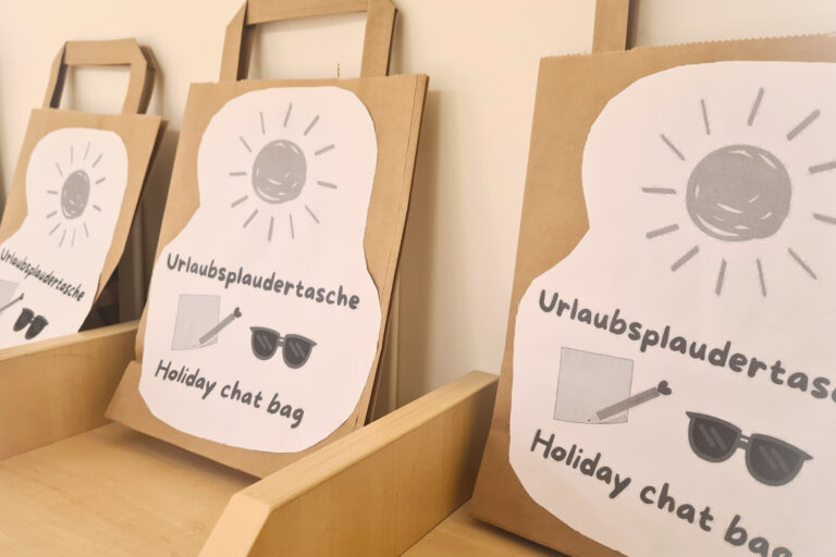 dreieins bilinguale Kindertagesstätte Berlin-Kaulsdorf - Urlaubsplaudertasche: Dargestellt sind Papiertüten in Regalfächern