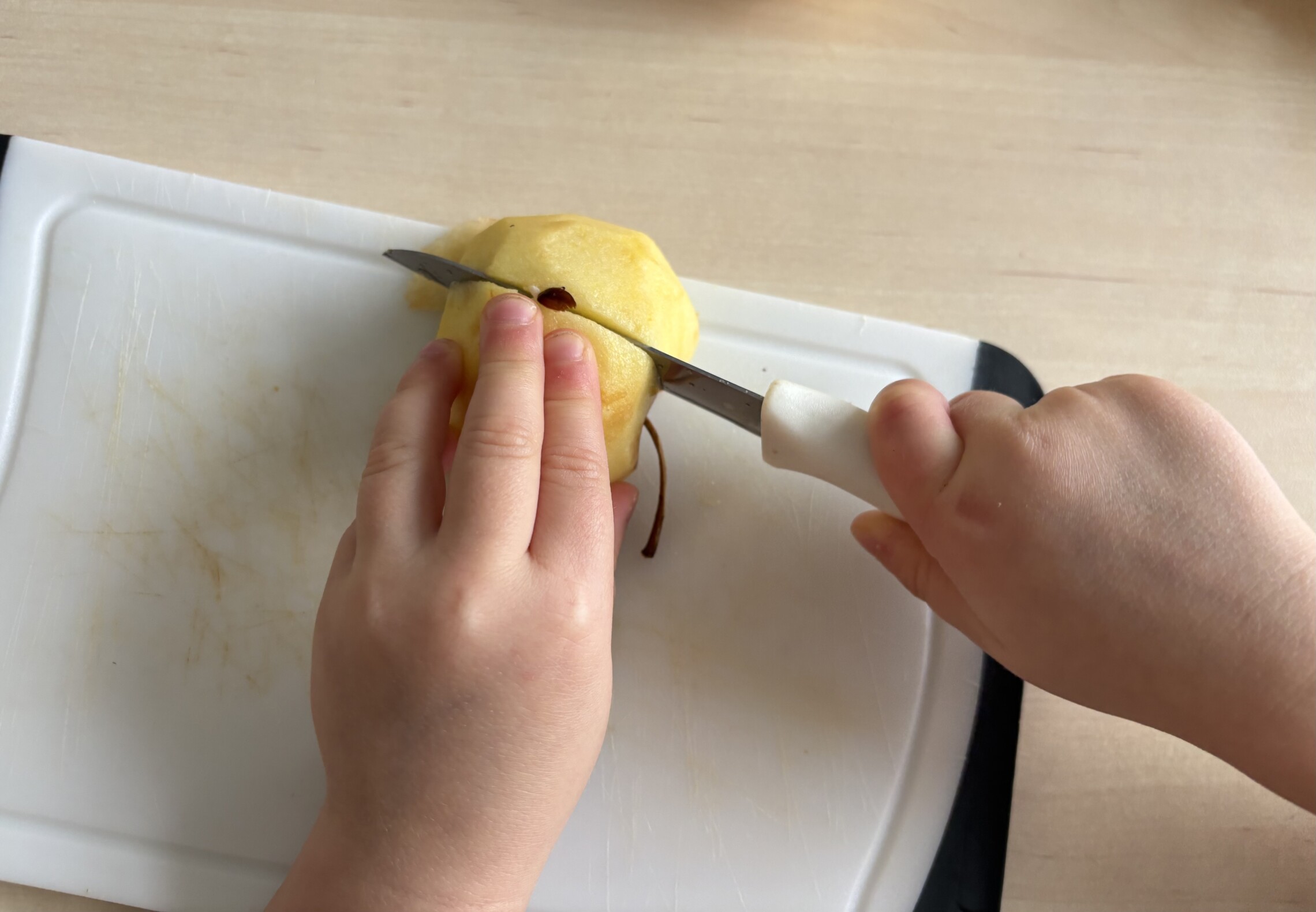 Mit dem Messer einen Apfel schneiden. 