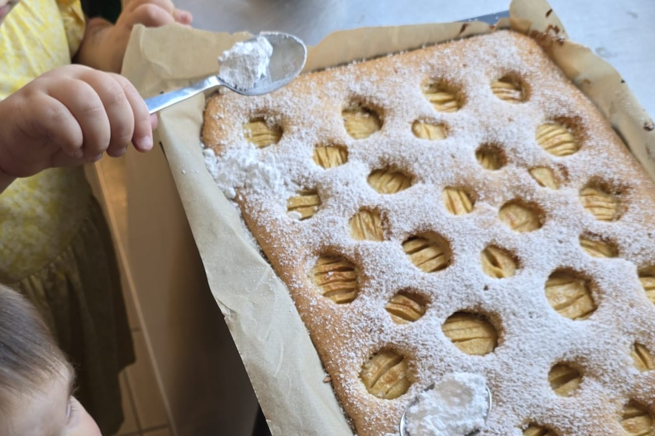 den Apfelkuchen mit Puderzucker bestreuen