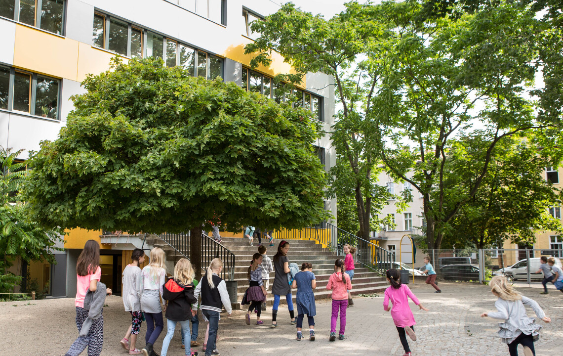 Nachhaltige Zukunft für die die dreieins Grundschule Berlin-Pankow: Auf dem Bild zu sehen, sind Kinder die auf den Eingangsbereich der Grundschule laufen.