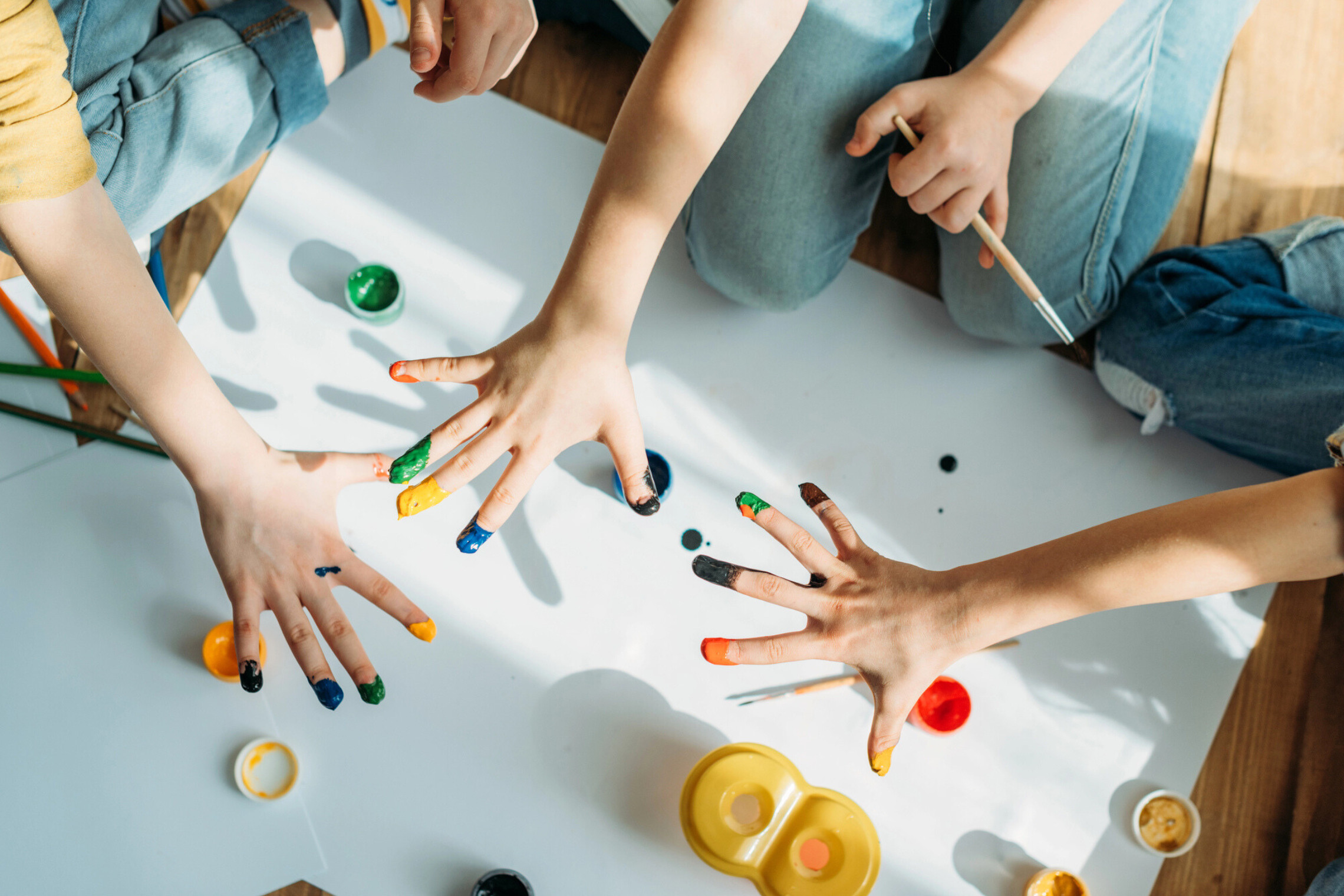dreieins Innovative Pädagogik – dreieins Kreativitätspädagogik: Zu sehen sind Kinderhände, die bemalt sind.
