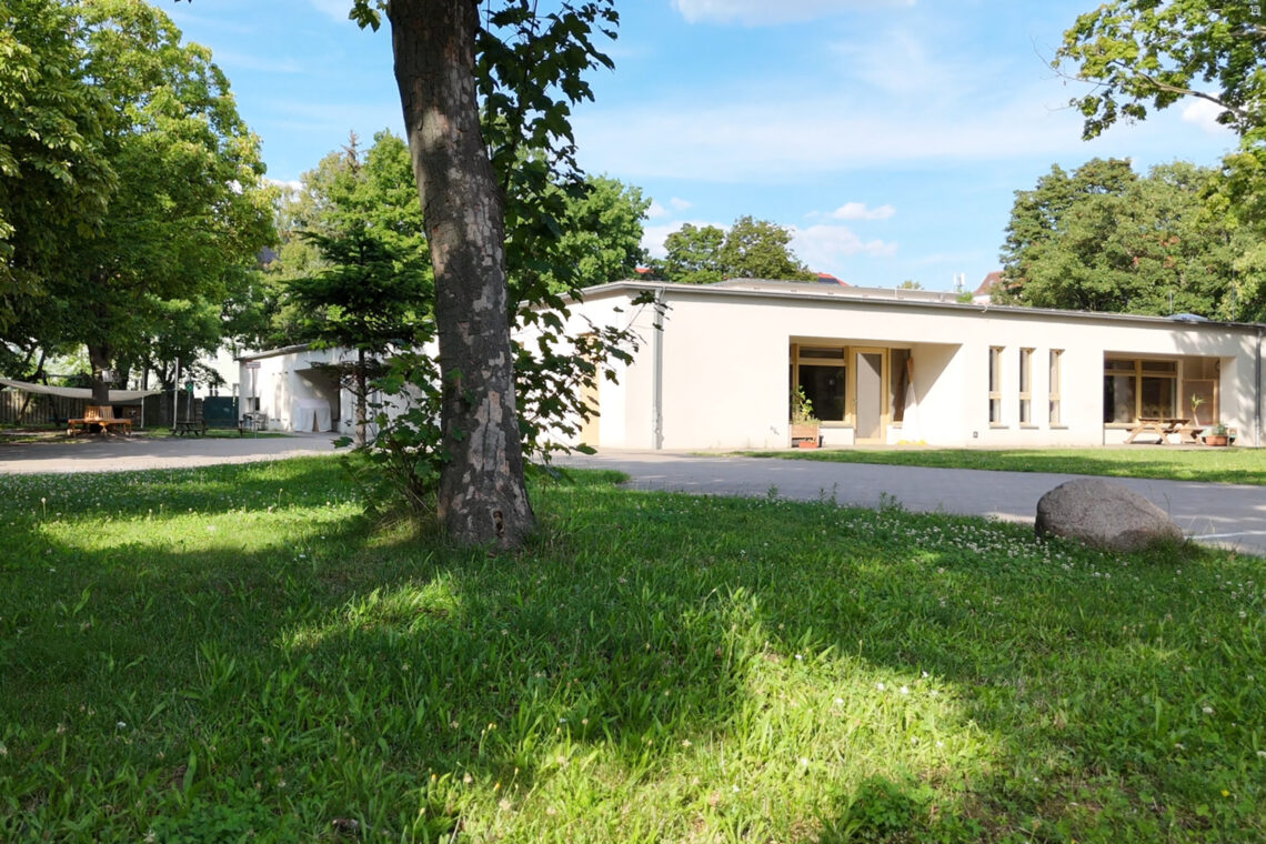 dreieins Innovative Pädagogik – dreieins Kindertagesstätte Prenzlauer Berg Gebäude: Abgebildet ist das Gebäude und ein Teil des Gartens der dreieins Kita Prenzlauer Berg.